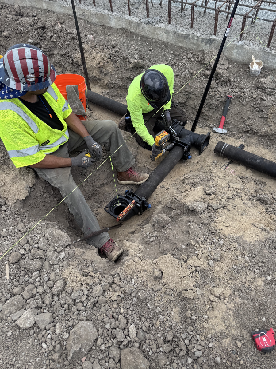 Crew connecting underground fire service pipe in an open trench